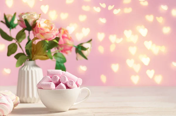 Holiday świąteczny romantyczny stół ozdobiony kwiatami i filiżanka z poink pianki — Zdjęcie stockowe
