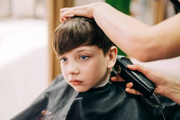 Corte de pelo para niño pequeño, peluquero profesional haciendo corte de pelo. Peinado para niños —  Fotos de Stock