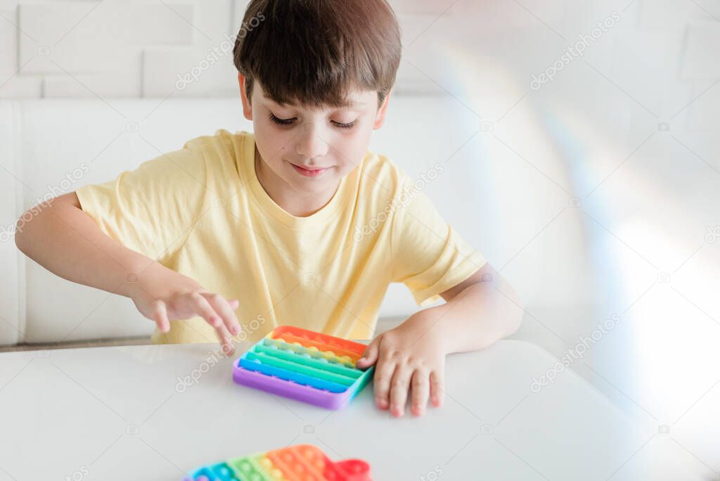 Young Little kid boy playing pop it -New Fidget Toy, Popular With Kids, Helps Them To Concentrate