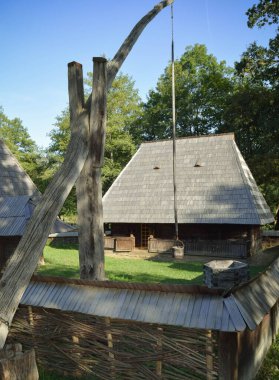 Bahçesinde ahşap ev ve çeşme bulunan geleneksel Romen evi