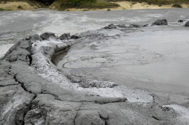 Çamur yanardağının köpüren krateri. Çamur volkanı kraterinde patlayan gaz kabarcığına yakından bak. Romanya 'nın Buzau kenti yakınlarındaki Paclele Mari' de çamur volkanı.