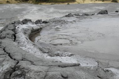 Çamur yanardağının köpüren krateri. Çamur volkanı kraterinde patlayan gaz kabarcığına yakından bak. Romanya 'nın Buzau kenti yakınlarındaki Paclele Mari' de çamur volkanı.