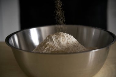 İnsan elleri ekmek, makarna, pasta ya da pizza yapmak için un hamuruna tuz ve maya ekler. Mutfağının ahşap masasında aşçı ev yapımı makarna geleneğini sürdürür..