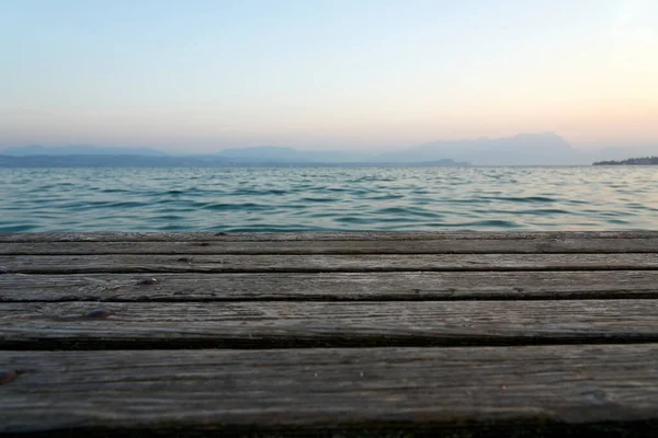าเร อไม กระดานบนทะเลสาบในช วงพ นหล งพระอาท มมองกระดานไม บนน าทะเลสาบ Garda — ภาพถ่ายสต็อก