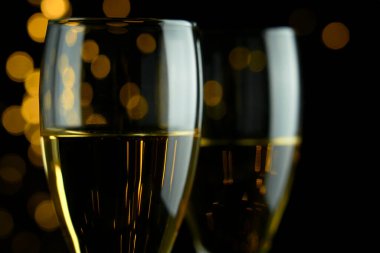 Kutlamak için iki bardak köpüklü şarap ya da şampanya. Parti ya da arka planda sarı bokeh etkisi olan yıldönümü.. 