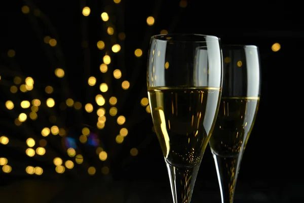 パーティーや記念日を祝うためにスパークリングワインやシャンパンの2つのグラス暗い背景に黄色のボケ効果 ストックフォト