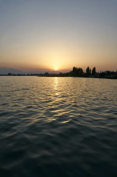 ณสว ยบสงบในทะเลสาบก บดวงอาท นเหน อเน นเขา าทะเลสาบ Garda กระจกส อบอ — ภาพถ่ายสต็อก