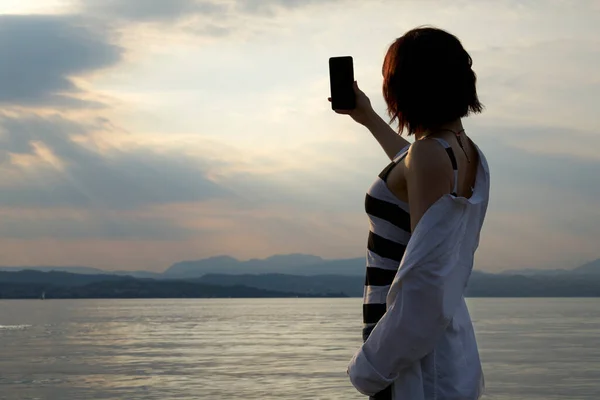 Tangan Wanita Memegang Smartphone Dan Membuat Foto Saat Matahari Terbenam — Stok Foto