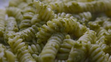 Pesto alla genovese soslu tipik İtalyan makarnası. Pesto, fesleğen, çam fıstığı, ekstra saf zeytinyağı ve grana peyniri ile yapılan geleneksel Akdeniz yeşil sosudur. Döndürme tabağı.