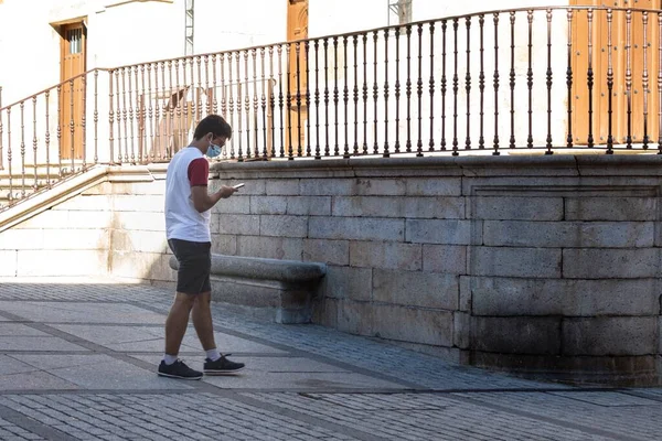 Jovem Caminhando Por Uma Praça Românica Usando Telefone Celular Para — Fotografia de Stock