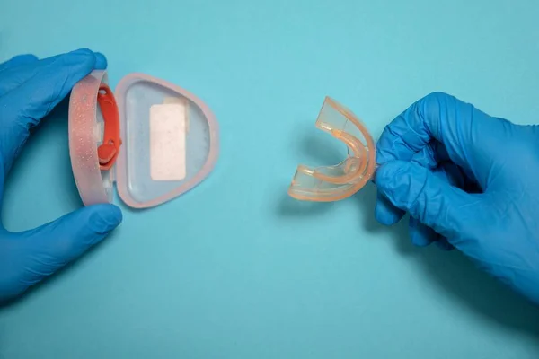 Bir doktorun ya da hemşirenin mavi lateks eldiven giyip, çocuğun dişlerindeki sorunu çözmek için plastik kalkanı çıkardığı seçici odak noktası.