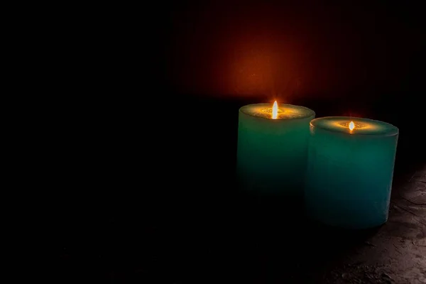 Селективное фокусирование двух зажженных свечей на черном фоне — стоковое фото