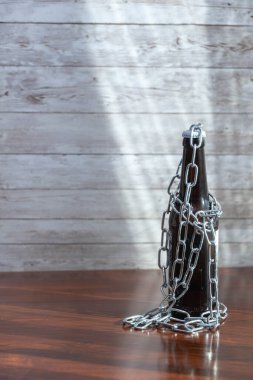 Zincirli bira şişesi güneş ışığıyla aydınlatılıyor otellerin kapanması için ahşap bir taban ve kovid19 ve alkolizm için barlar.