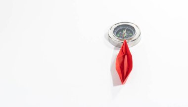 Pembe kağıt bir teknenin seçici odak noktası ve uluslararası kadın günlerinde kadın liderliği kavramının kuzeyi işaretleyen bir pusula.