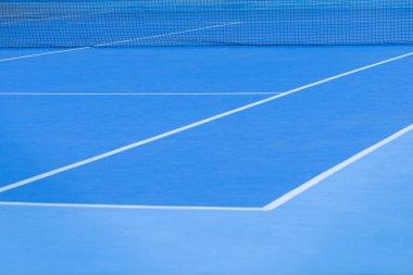 Mavi ve beyaz çizgileri olan boş bir tenis kortunun ayrıntıları