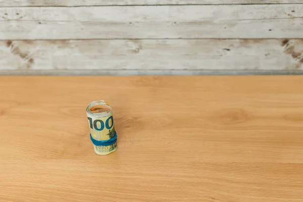 Büyük miktarda nakit paranın seçici odağı toplanmış ve plastik bant ile fotokopi alanı ekonomisine sahip ahşap bir masanın üzerinde tutulmuştu.