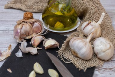 Sarımsak soğanları ve karanfiller yağ ve seçici bir odak noktasıyla kesmek için bir bıçak..