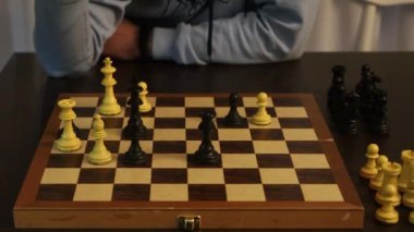 Bir gencin satranç tahtası oyununu oynadığı ve şah mat olarak sona erecek bir hamle yaptığı ve kralı masanın üzerine yuvarladığı video..