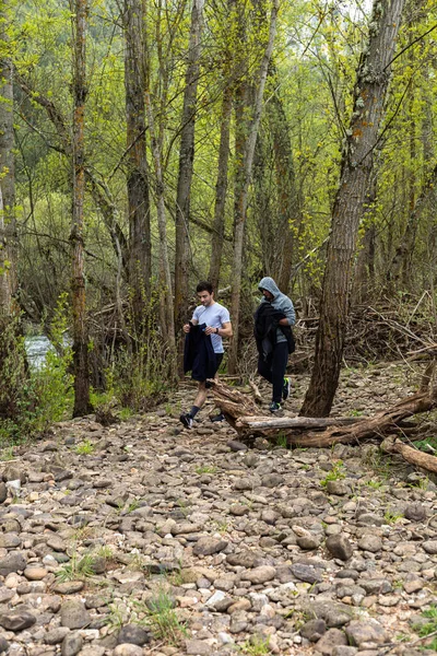 两名少年在乡村溪流边远足 还有一些树木 他们有选择地把重点放在健康自然的远足上 — 图库照片