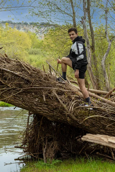 Jonge Tiener Klimmend Een Omgevallen Boomstam Met Een Houding Van — Stockfoto