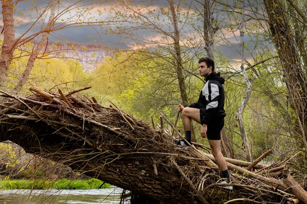 Junger Mann Sportbekleidung Und Kurzen Hosen Klettert Auf Einen Umgestürzten — Stockfoto