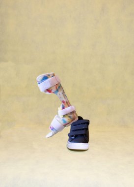 Felçli ayak ortotikleri ve mavi spor ayakkabılı Dafo ortotikler için rehabilitasyon hem sarı arka planda cırt cırt bağlayıcı hem de çocuk maluliyet konsepti için kopyalama alanı