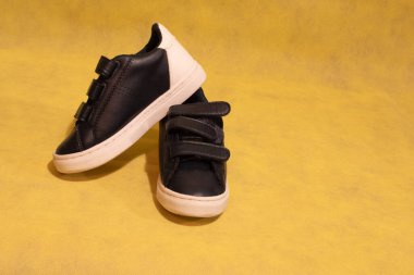 Sarı arkaplanda cırt cırtlı mavi spor ayakkabılar ve kopyalama alanı