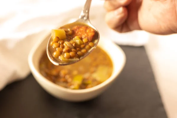 Persona Che Mangia Lenticchie Con Porro Chorizo Con Cucchiaio Fuoco Immagine Stock