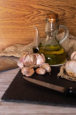 Sarımsak ve sarımsak yağlı bir masanın seçici odak noktası aromalı ve tarepeutik ve iyileştirici özellikli sarımsak yağı veya baharatlı salata ve yemek için.