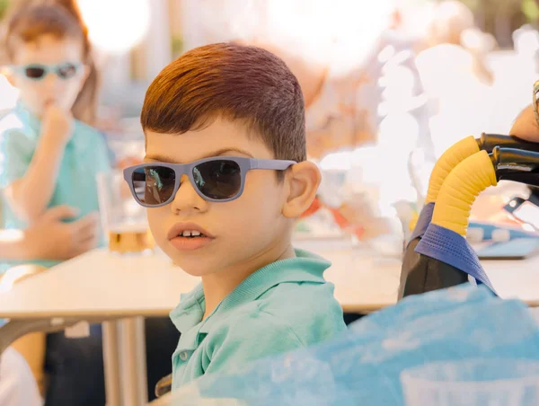 선글라스를 휠체어에 소년의 초점을 맞추지 뒤에서 남동생 장애때문에 휠체어에 소년의 — 스톡 사진