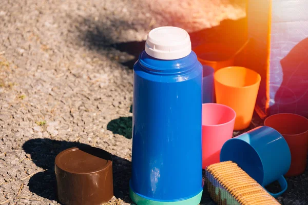 Plastikthermoskannen Mit Plastikbechern Verschiedenen Farben Neben Ein Paar Quadratischen Keksen — Stockfoto