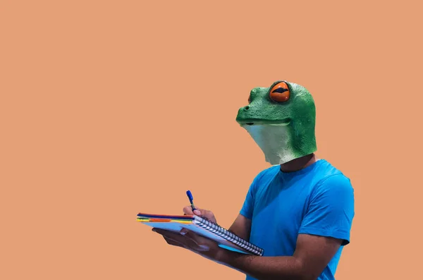 Geste Einer Person Mit Froschmaske Mit Notizbuch Und Stift Zum — Stockfoto