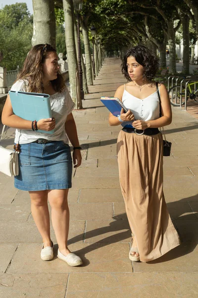 Duas Universitárias Caucasianas Passeando Falando Sobre Estudos Enquanto Seguram Pastas — Fotografia de Stock