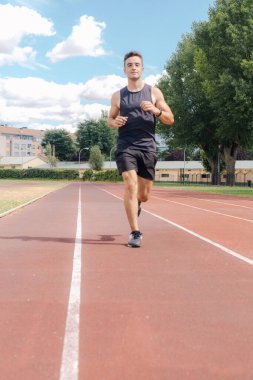 Kopya alanı ile antrenman yaparken koşu pistinde koşan genç bir atlet