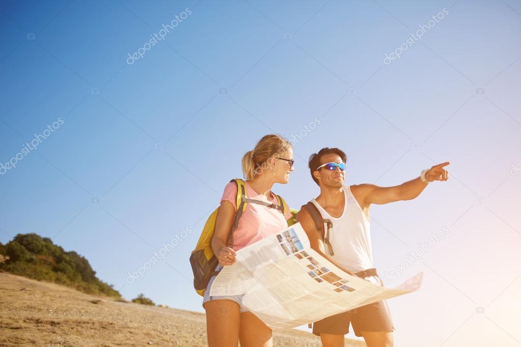 Cheerful happy tourists are enjoying beautiful nature view during hike in mountains