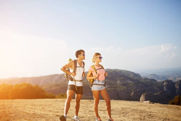 Dos excursionistas de pie en alta montaña en el soleado día de verano durante sus vacaciones conjuntas en el extranjero — Foto de Stock