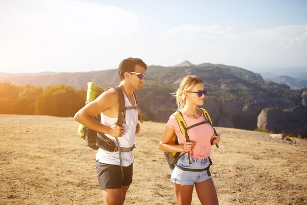 Dos viajeros en gafas de sol están descansando después de caminar en las montañas durante su fin de semana — Foto de Stock