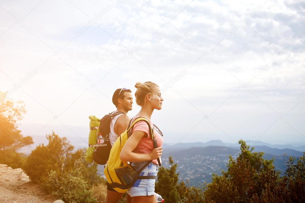 Two wanderers are taking break between walking in mountains during their summer adventure