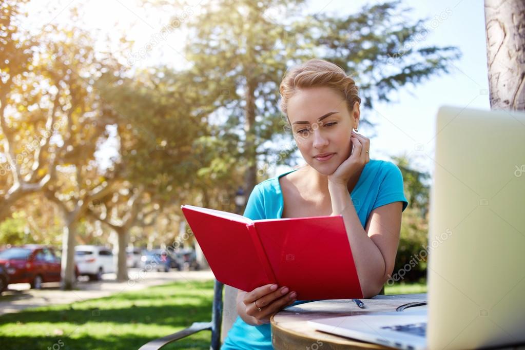 Young woman reading diary while