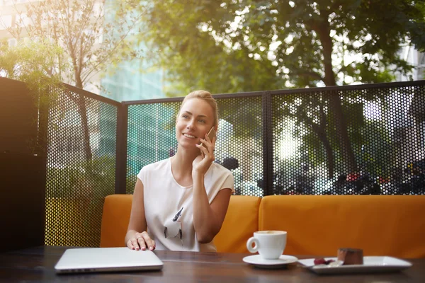 Mujer de negocios está teniendo placer conversación telefónica celular durante el descanso en la cafetería — Foto de Stock
