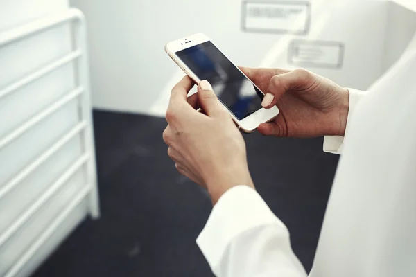 Las manos de las mujeres en la celebración de teléfono inteligente — Foto de Stock