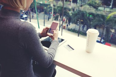 woman typing message on cell telephone