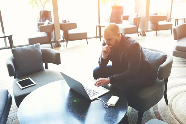 Broker maschile esaminando i documenti sul computer portatile — Foto Stock