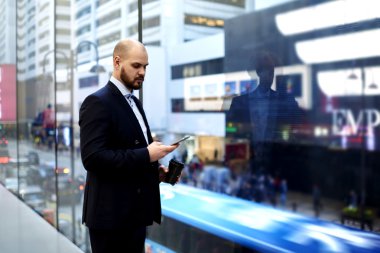 İşadamı cep telefonundan e-posta okuyor