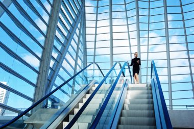 Woman using cell telephone on staircase 