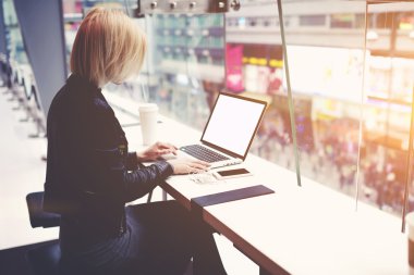 Young female freelancer with open laptop