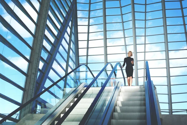 Junge Geschäftsfrau steht auf modernem Flughafen — Stockfoto