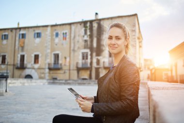  Elinde dokunmatik yüzey ile Büyüleyici kız öğrenci kameraya bakıyor