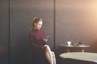 Genç güzel kadın izlerken video on-line Cafe iş molası sırasında cep telefon üzerinde kopyalama alanı