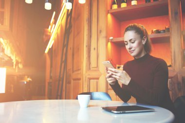 Çekici kız öğrenci çağdaş üniversite kitaplığında dinleniyor